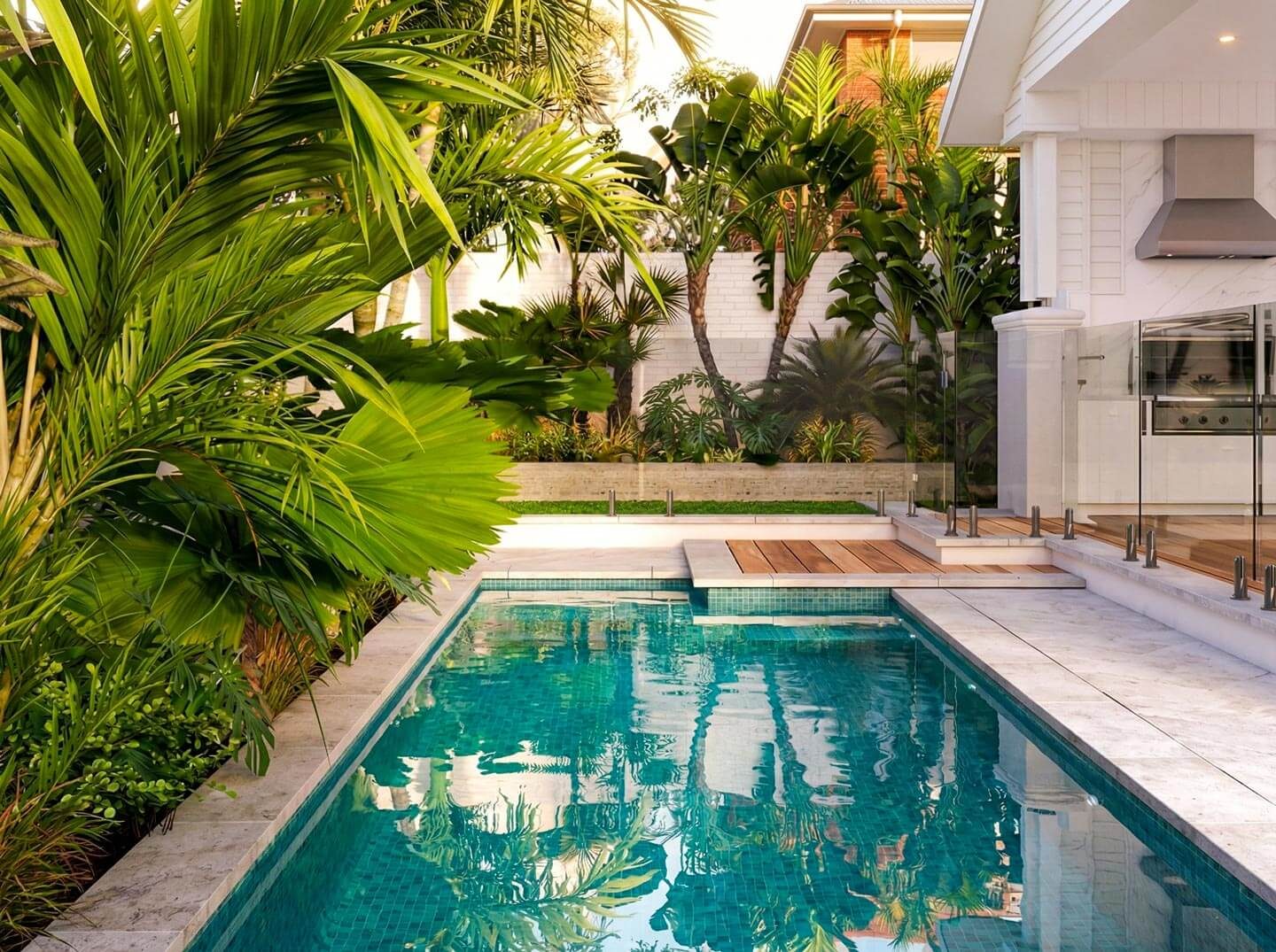 Tiled swimming pool with glass fencing and tropical palm trees Gold Coast.