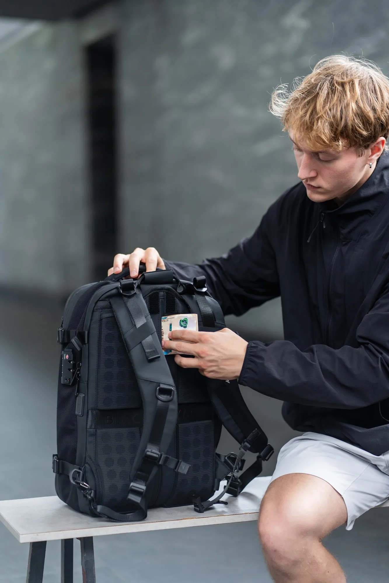 Hand tucking a banknote into the concealed textured back-panel pocket of the Zephyr Pro