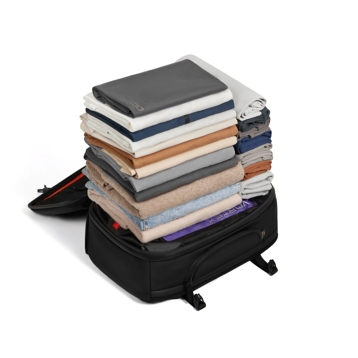 A full week of folded clothing stacked on the open Zephyr Pro, Vortex compression pouch visible inside