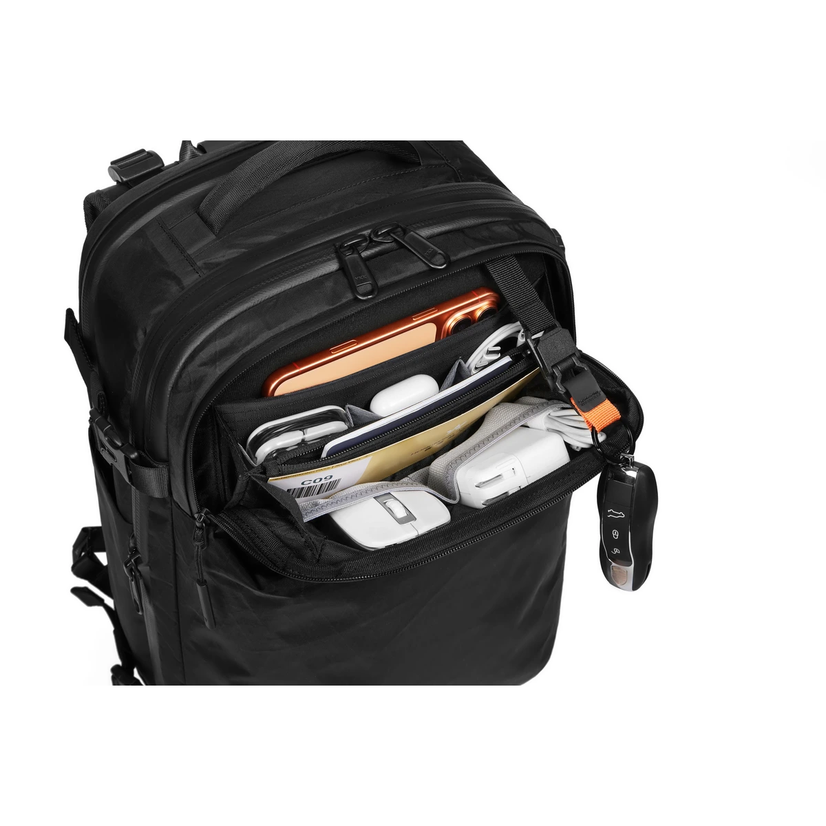 Front organizer pocket packed with phone, AirPods, cables, boarding pass and a wireless mouse