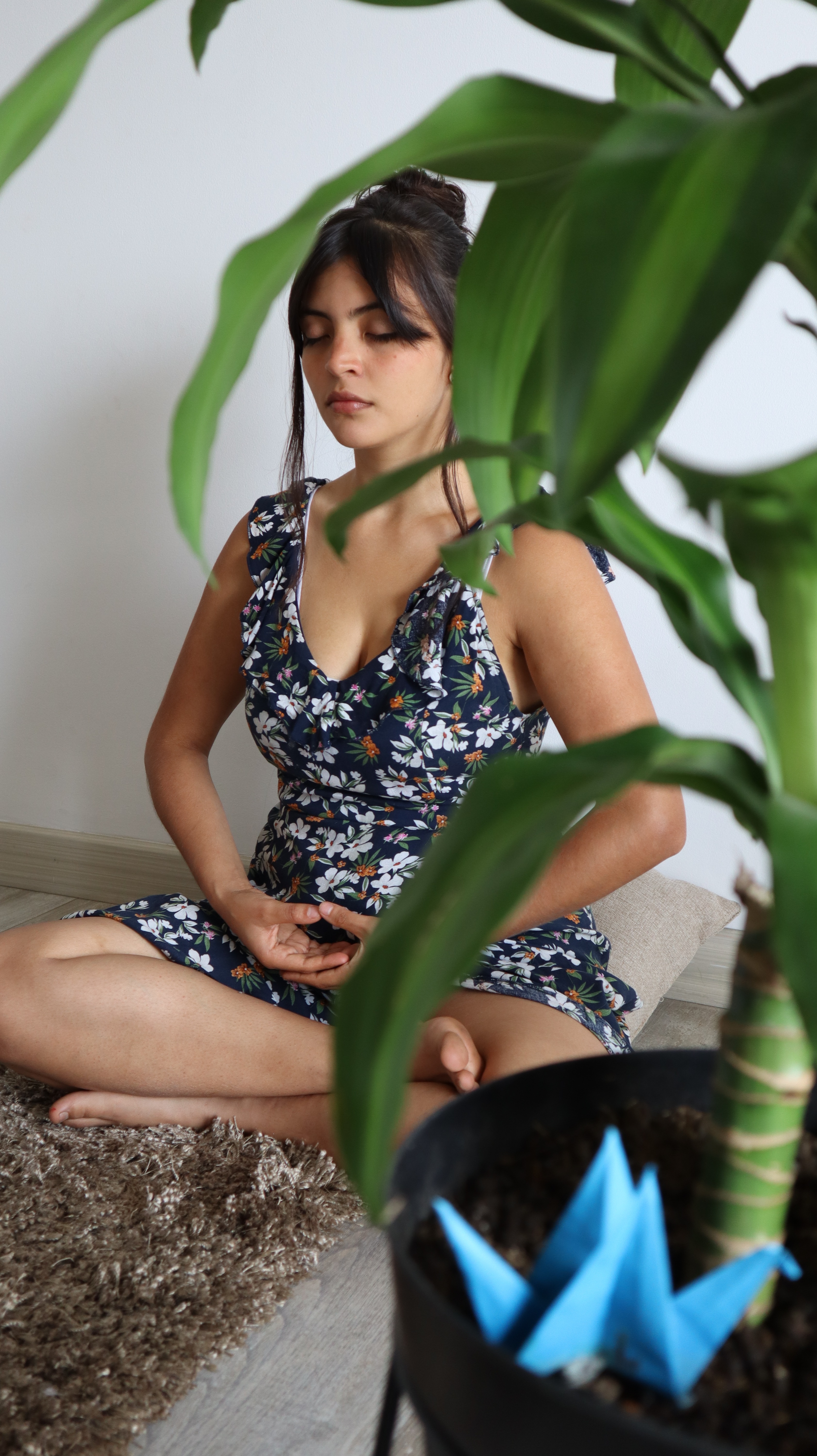 a woman, sitting on the floor in lotus posture