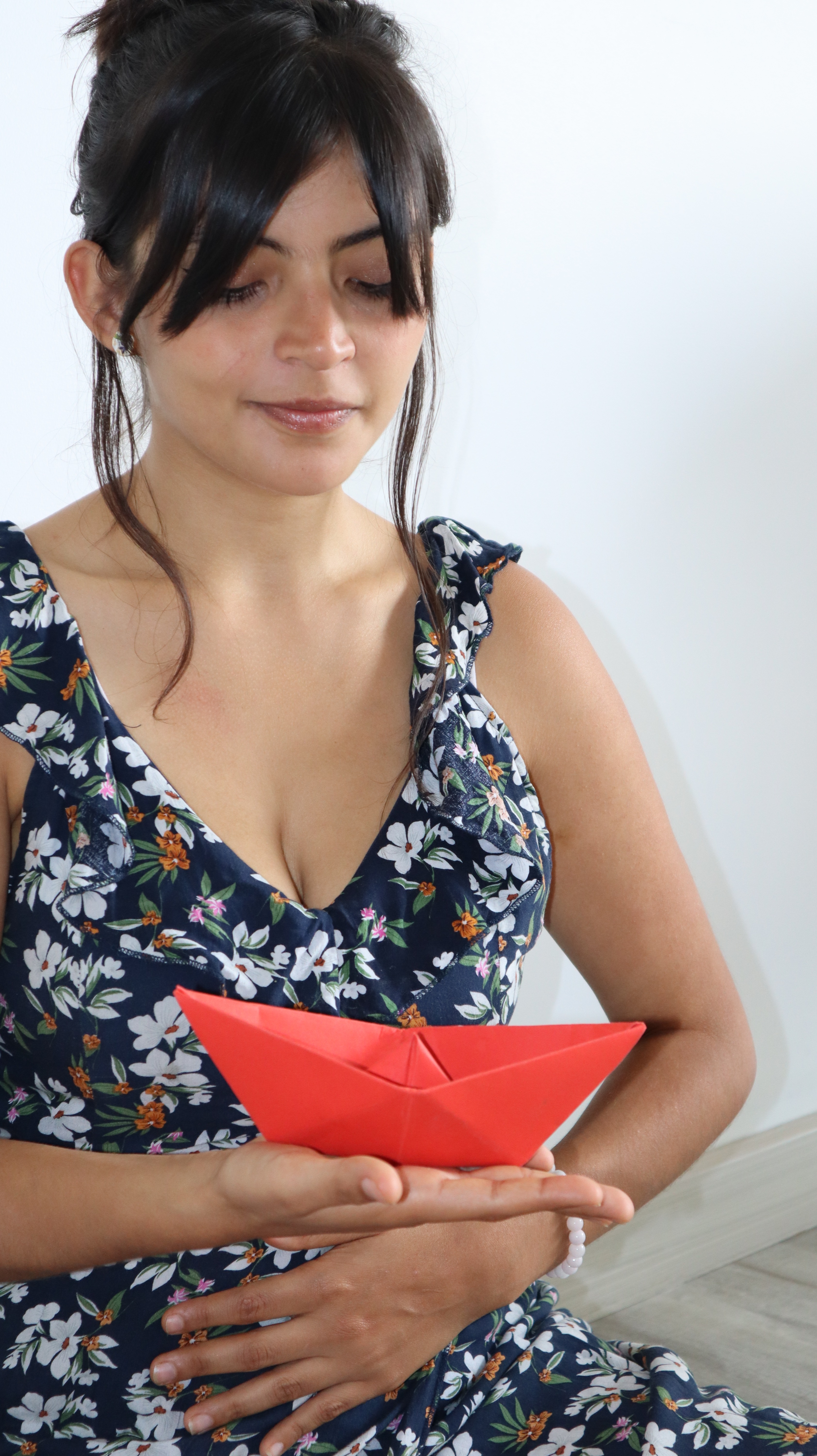 a woman holding a paper boat