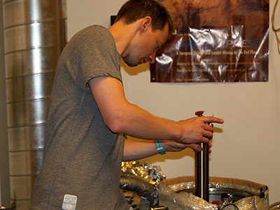Placing the rose into the chamber. The roses are placed in metalic tubes with an inner glass container. Inside the chamb