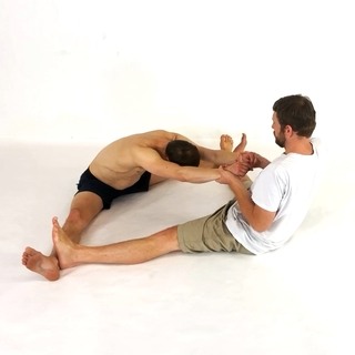 Partner sitting straddle stretch