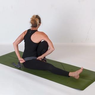 Strap-assisted revolved spinal twist