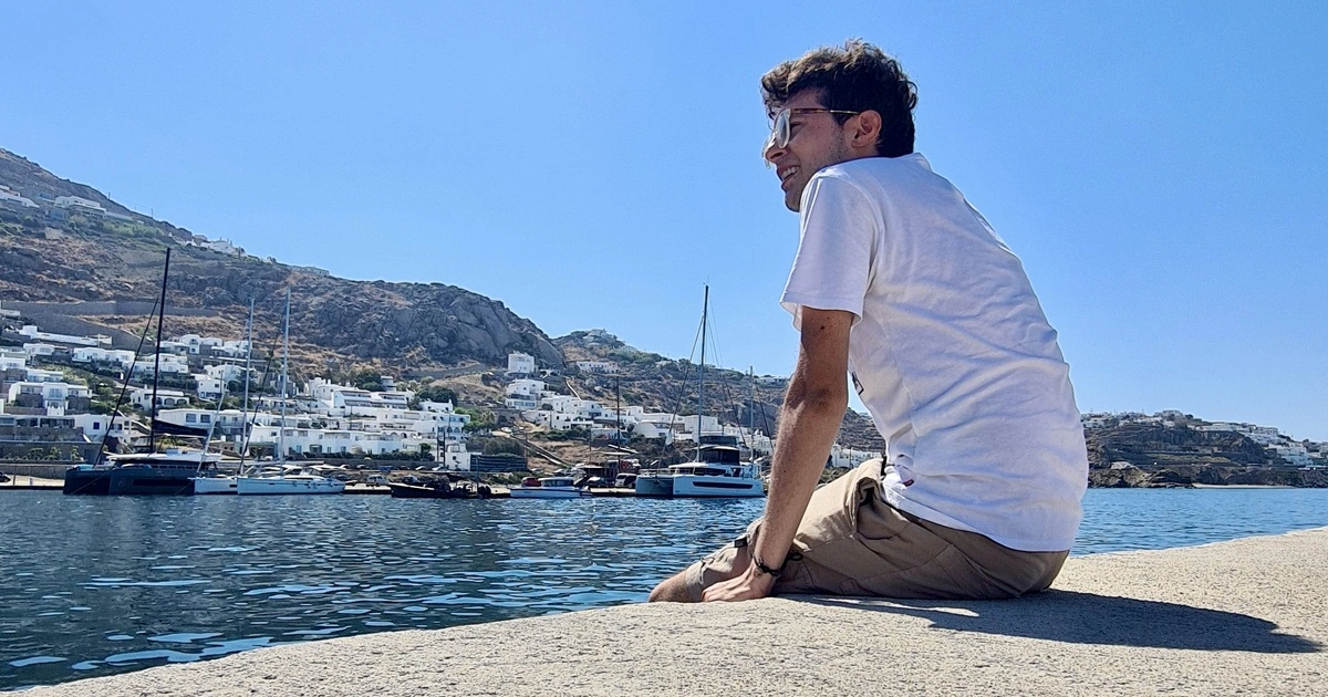 Photo of Camilo in the beach sitted on the bay.
