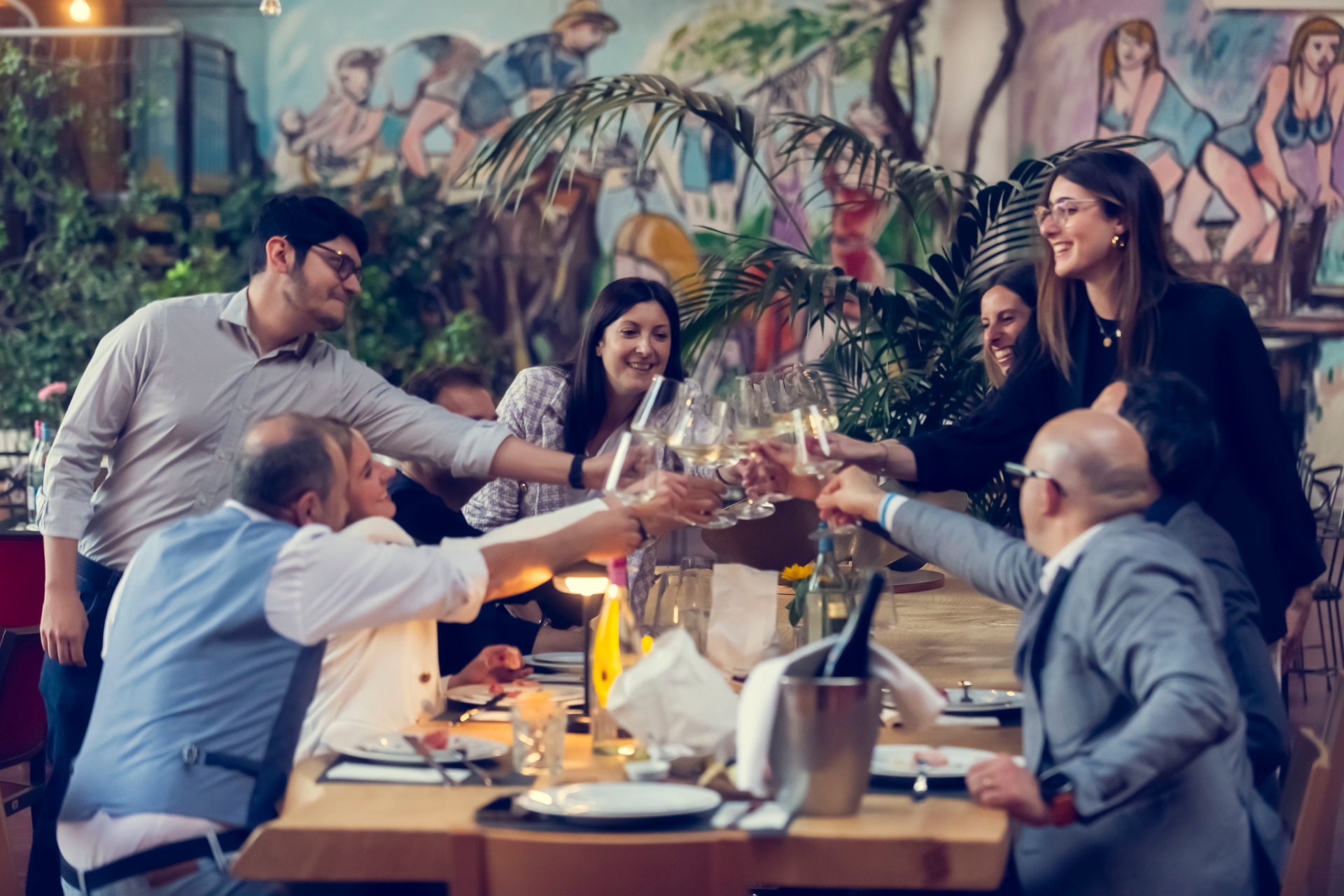 Un gruppo di persone che brindano insieme a un tavolo.