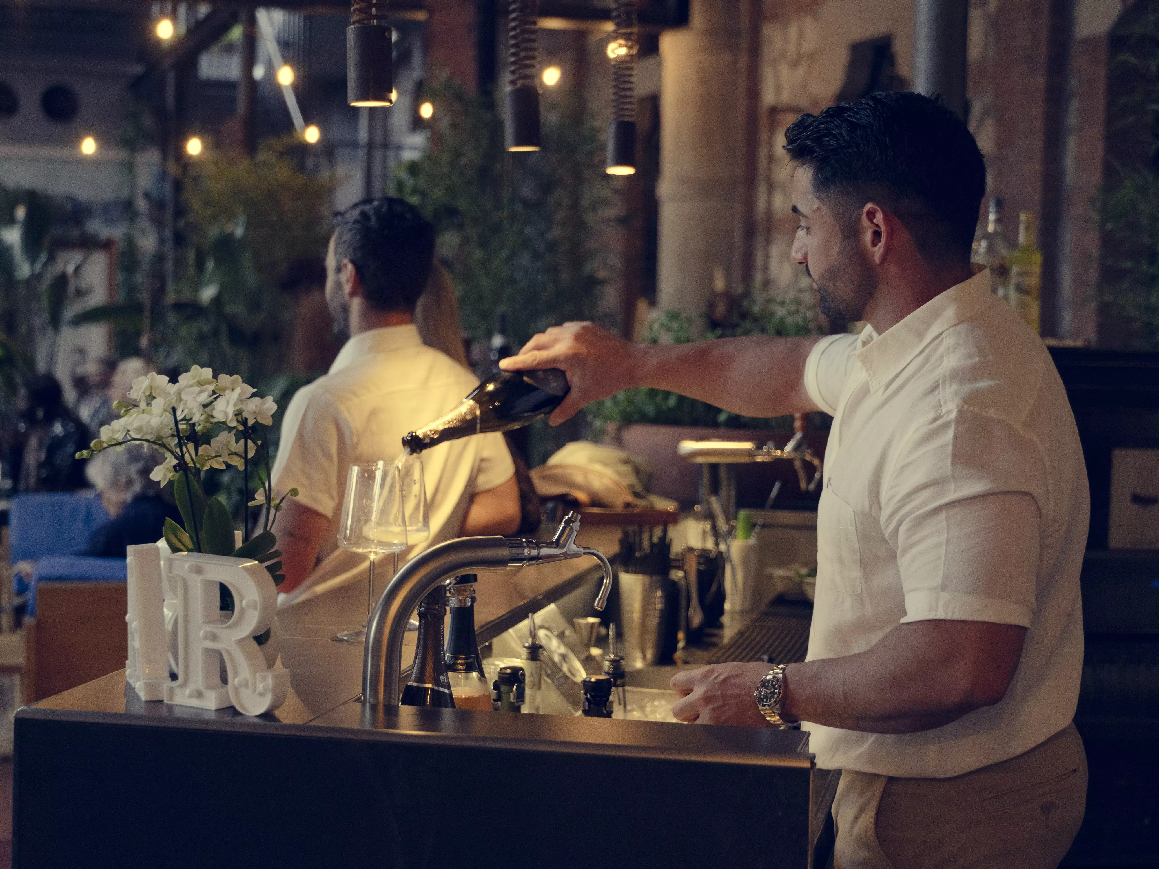 Un barista versa dello champagne in bicchieri.
