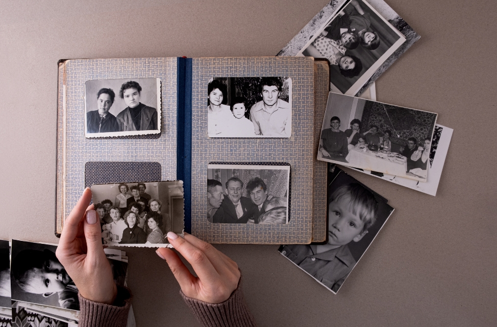 Hands holding a photo over an album.