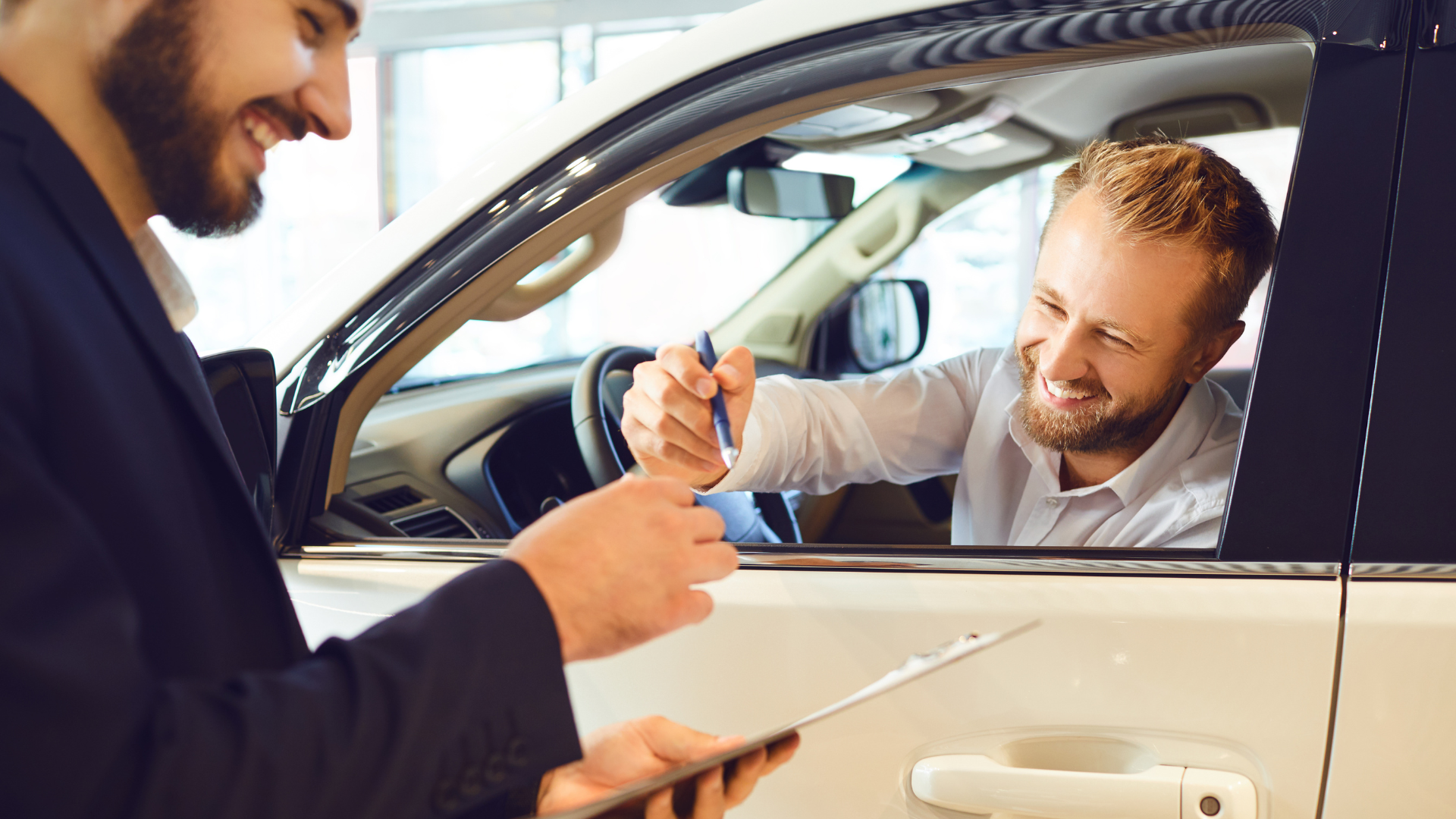 Acquistare un'auto è emozionante! Un cliente sorridente firma i documenti per la sua nuova auto.
