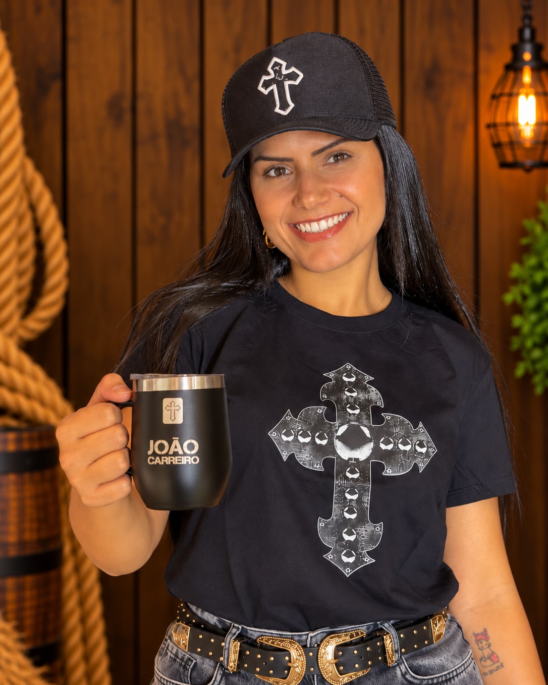 Camiseta Cruz do Chapéu vestida, com a caneca João Carreiro na mão