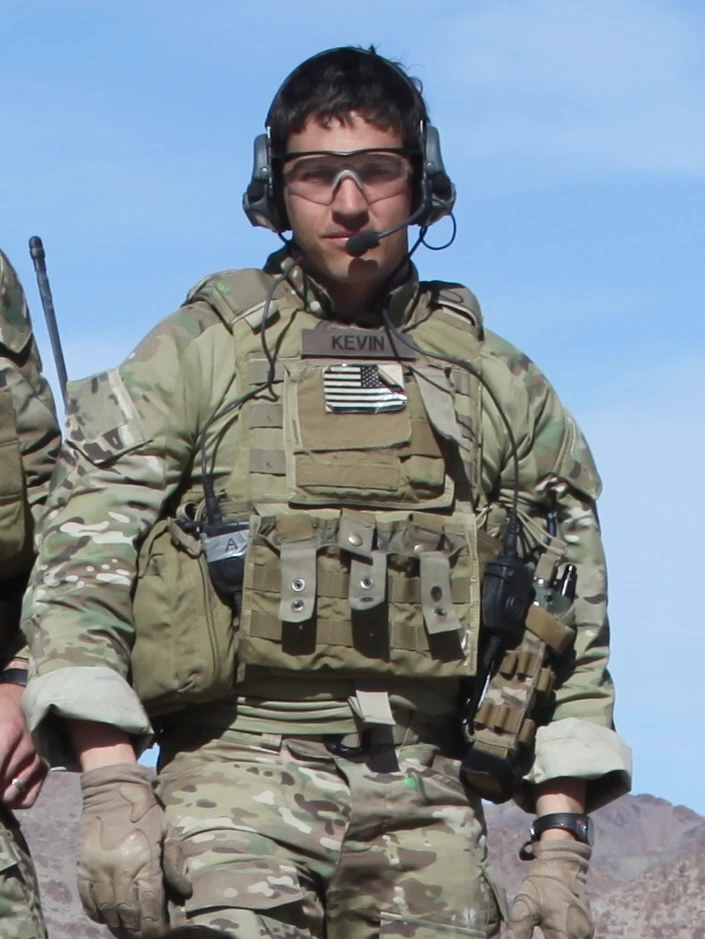 Kevin Horrigan standing outdoors wearing Special Forces gear during his military service.