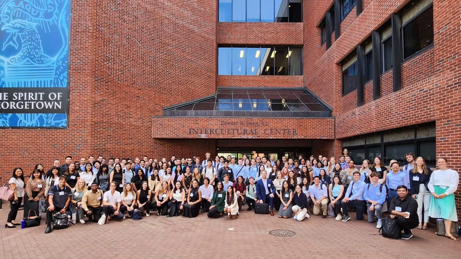 A group of STIA students standing together outside the Georgetown University Edward B. Bunn, SJ Intercultural Center.