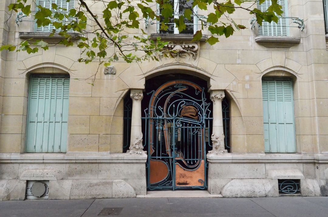 Le Castel Béranger d'Hector Guimard, porte d'entrée métallique ouvragée avec des plaques de cuivre, immeuble de style Art nouveau.