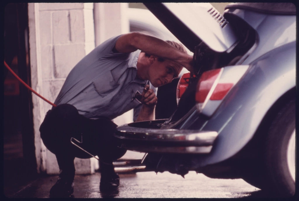 Service Station Mechanic Adjusts Engine