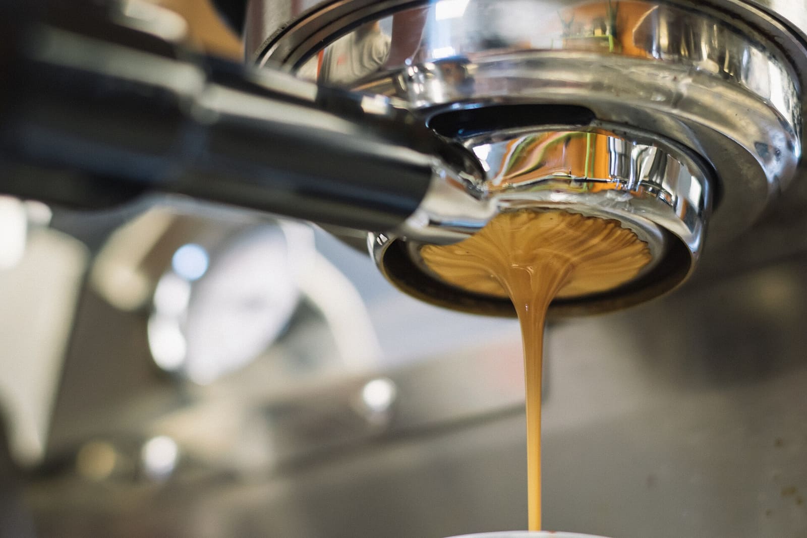 Golden espresso pouring from the portafilter