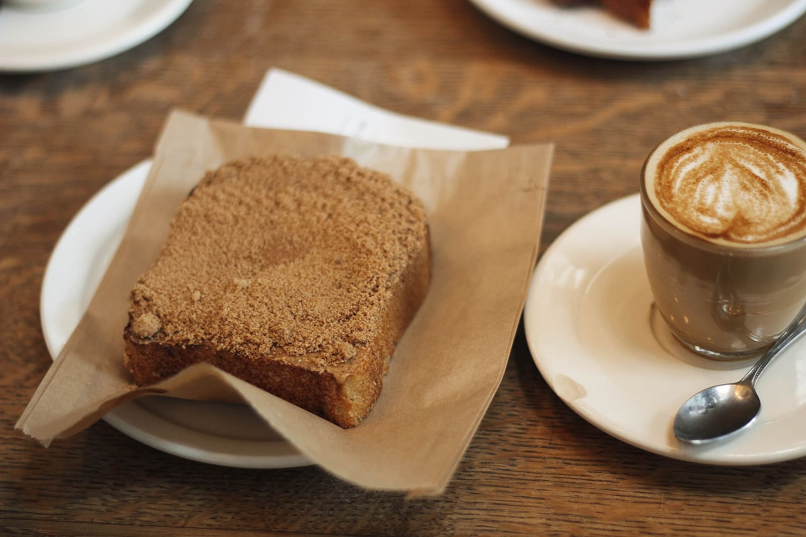 Homemade cake slice with a cortado on a wooden table