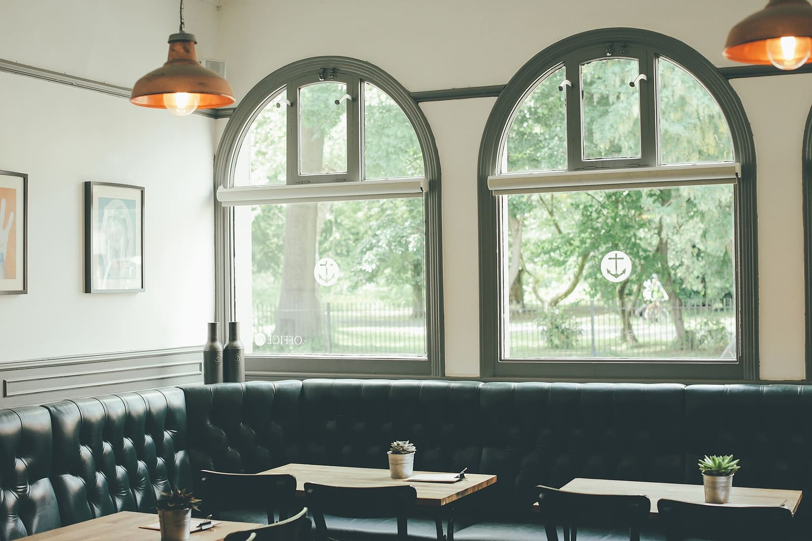 Calm café with arched windows and copper pendant lights