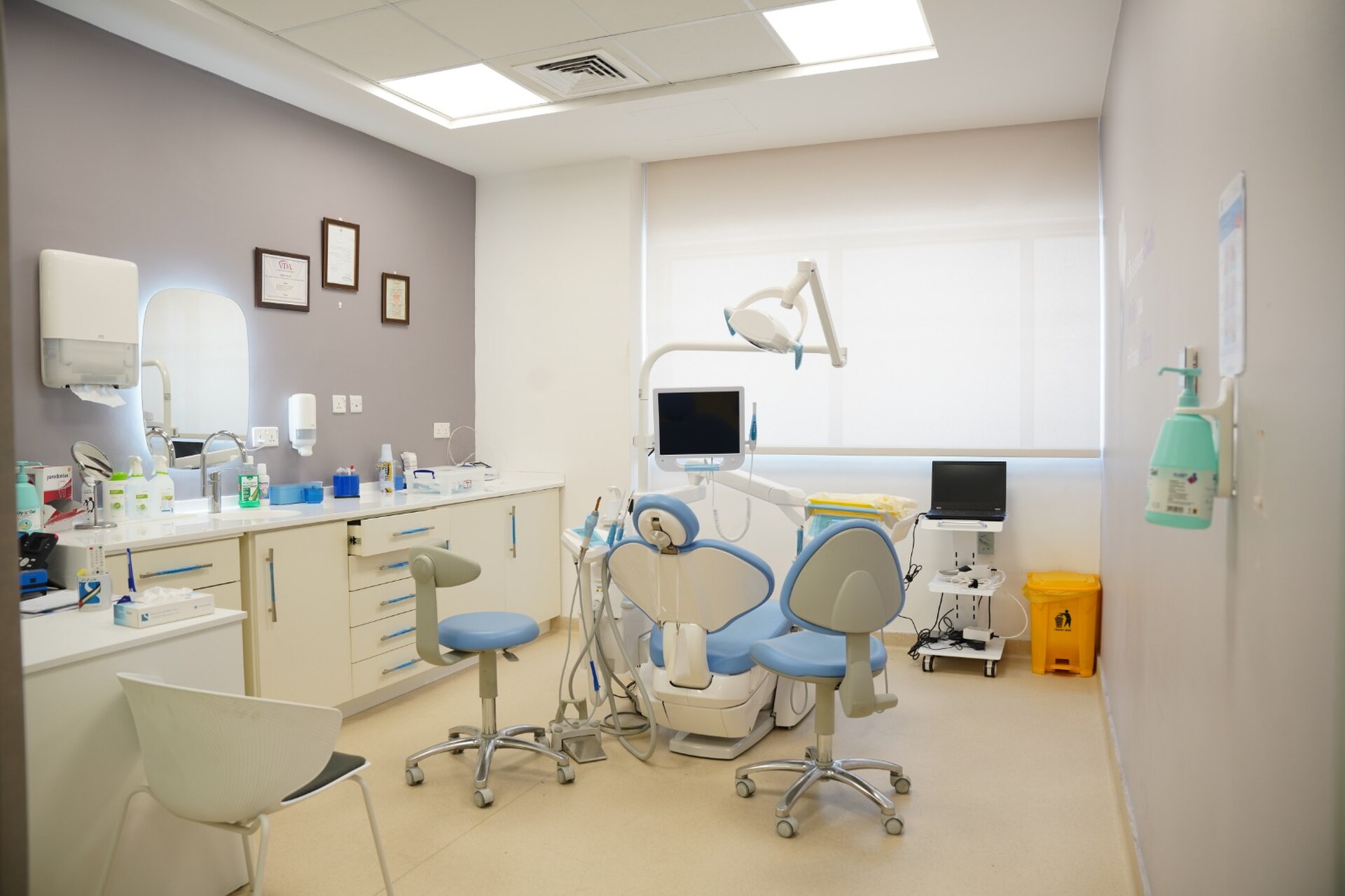 Tidy dental treatment room with light furniture