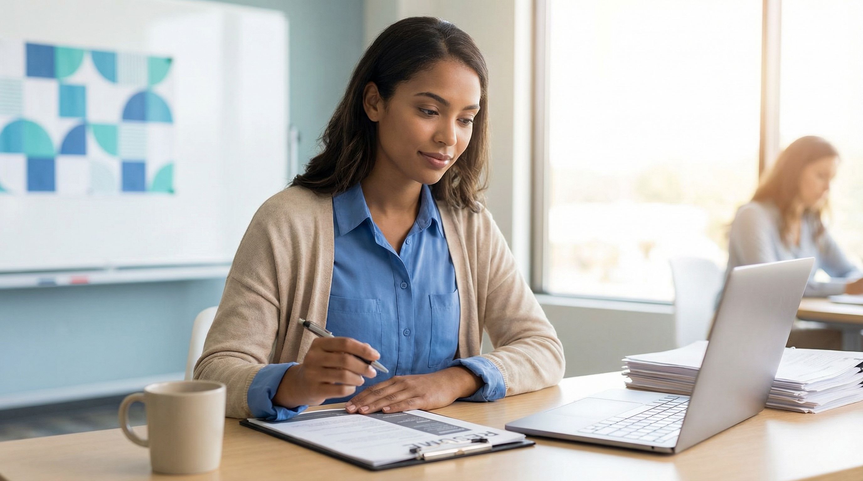 Behavior technician reviewing resume documents at a modern clinic desk with warm natural lighting