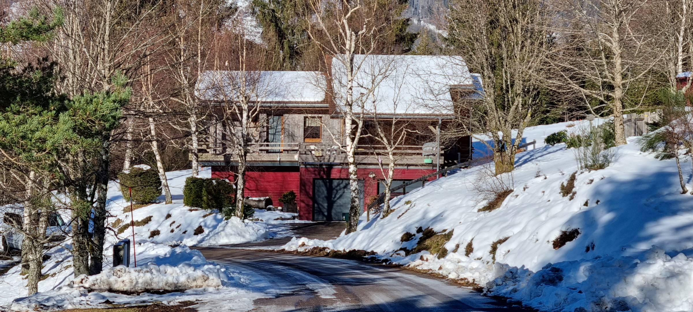 Le chalet sous la neige, entouré de sapins enneigés