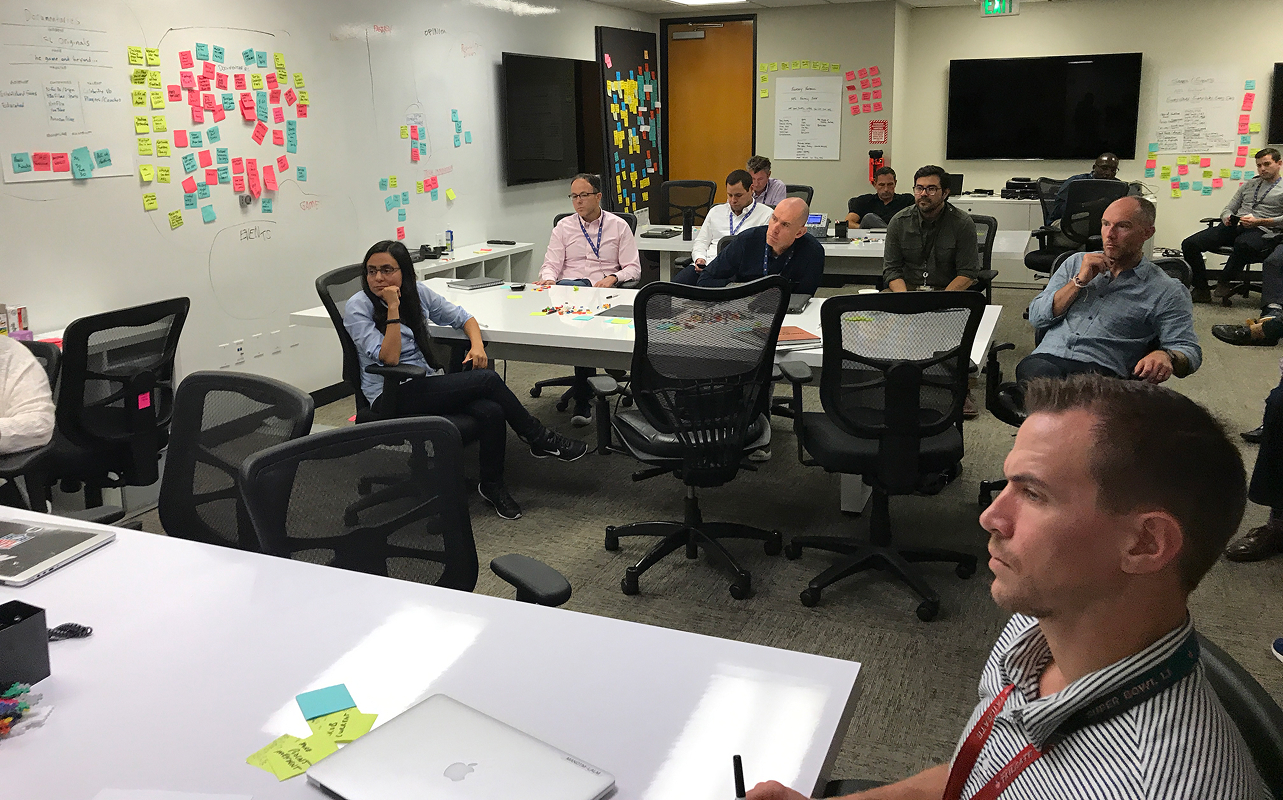 Cross-functional NFL Media team meets around tables surrounded by workshop boards covered in notes.