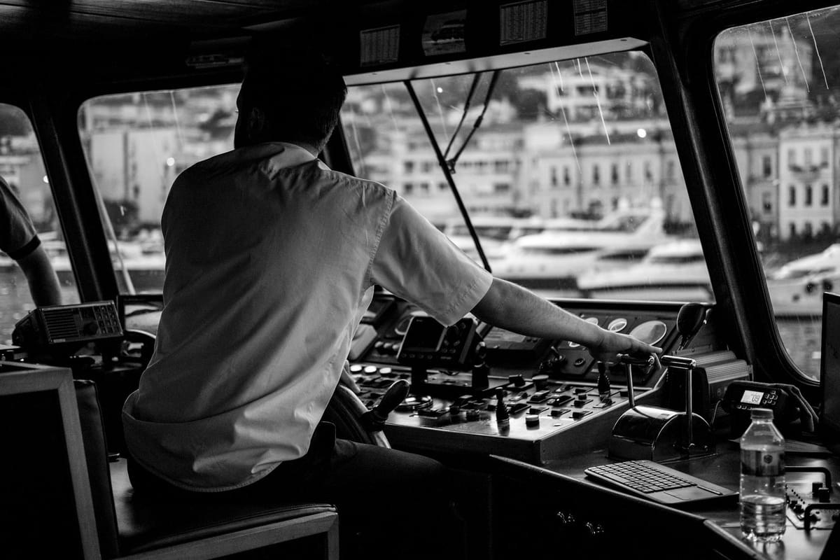 A licensed captain at the helm of a motor yacht cruising through the Florida Keys.