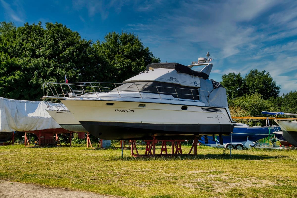 A motor yacht lifted out of the water in dry dock for hull inspection and repair.
