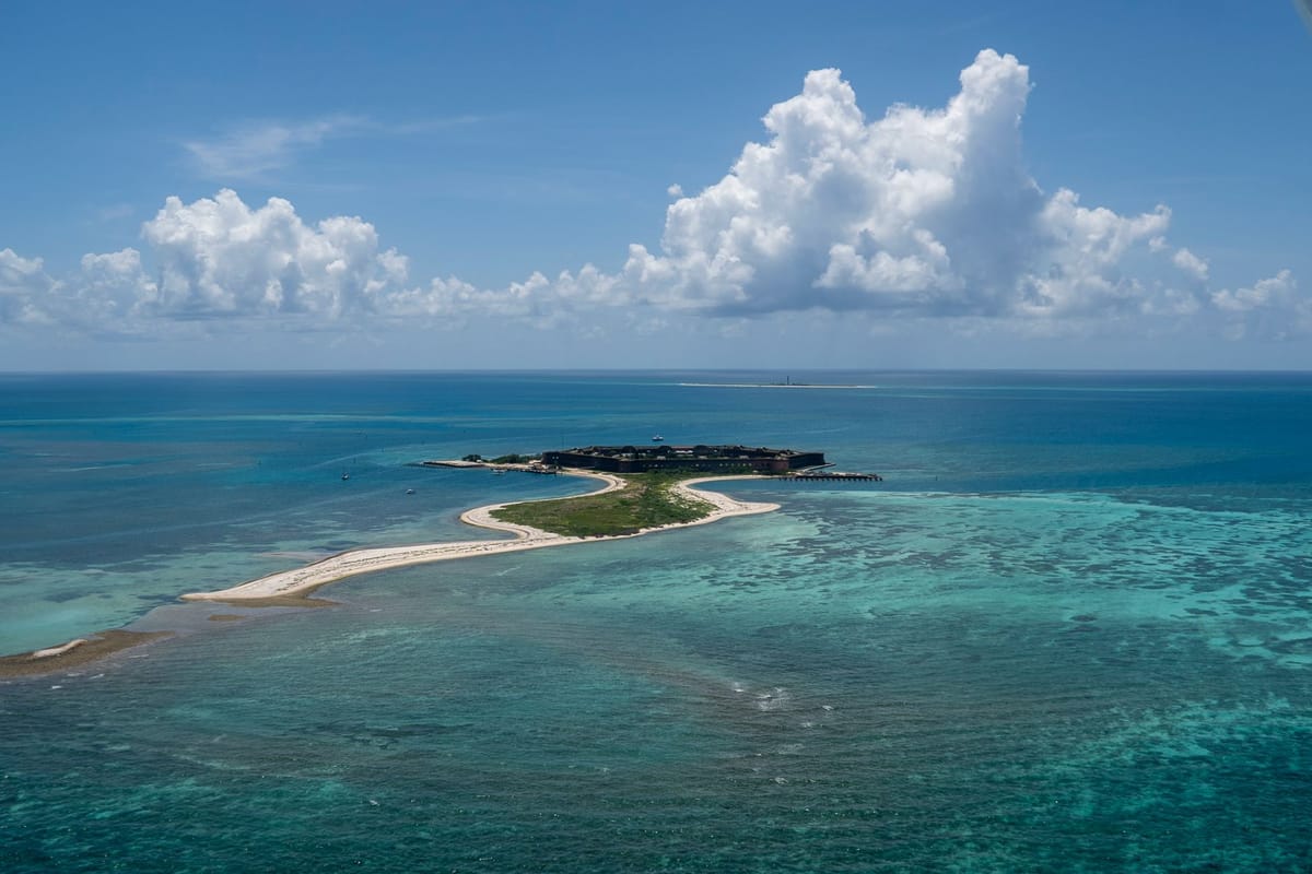 A sailboat anchored in turquoise water near Fort Jefferson at Dry Tortugas National Park.