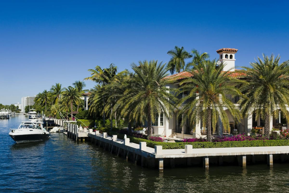 Aerial view of the Intracoastal Waterway in Aventura, Florida, lined with luxury yachts and waterfront homes.
