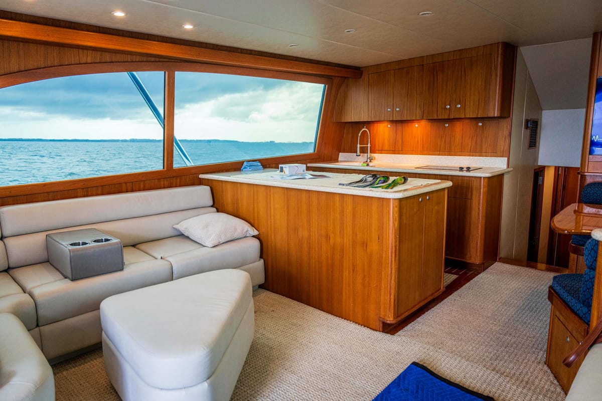 A luxury motor yacht cruises Biscayne Bay with the Miami skyline visible in the background.