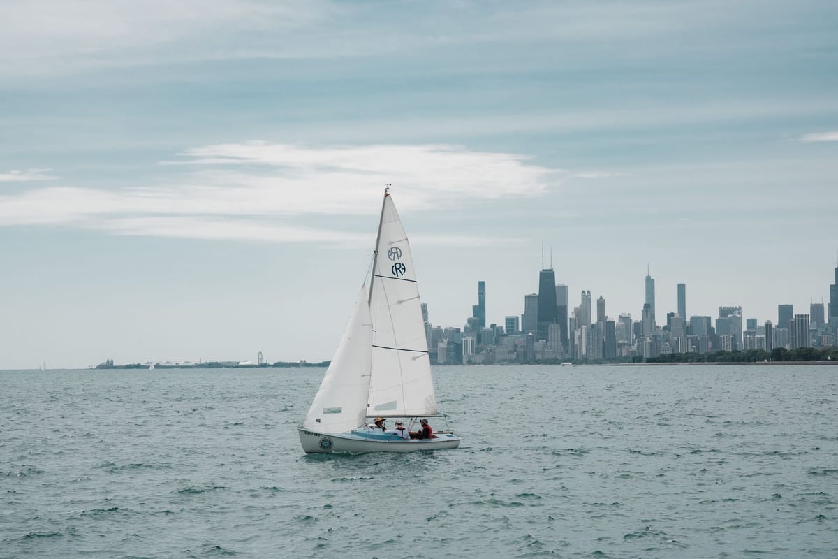 A fleet of sailboats racing on Lake Michigan with the Chicago skyline in the background.