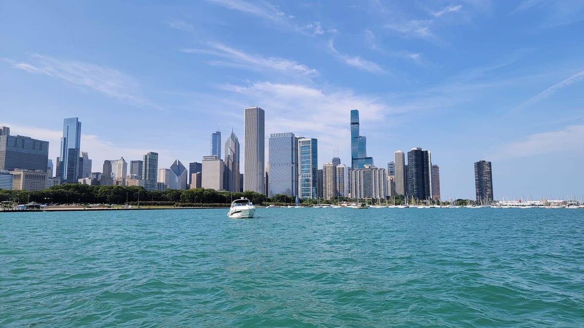A large fleet of sailboats racing across Lake Michigan with the Chicago skyline in the background.