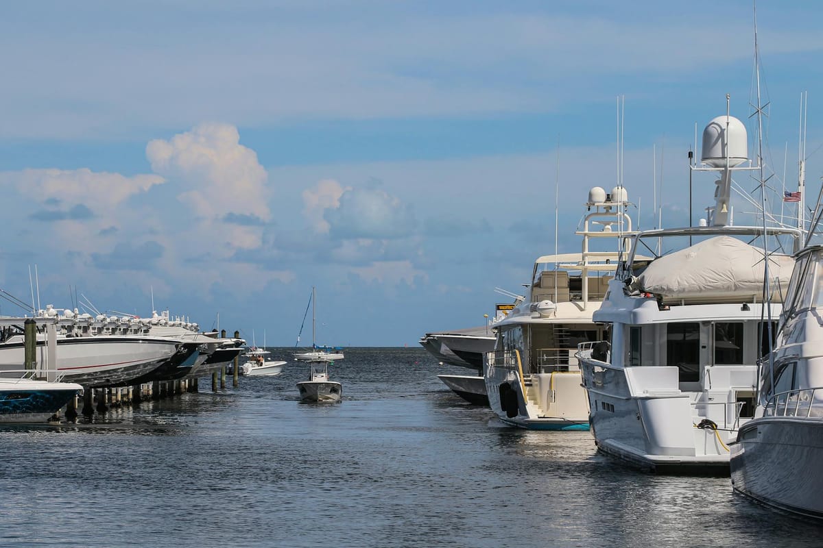 A 50-foot motor yacht cruising along the Miami coastline on a clear, sunny afternoon.