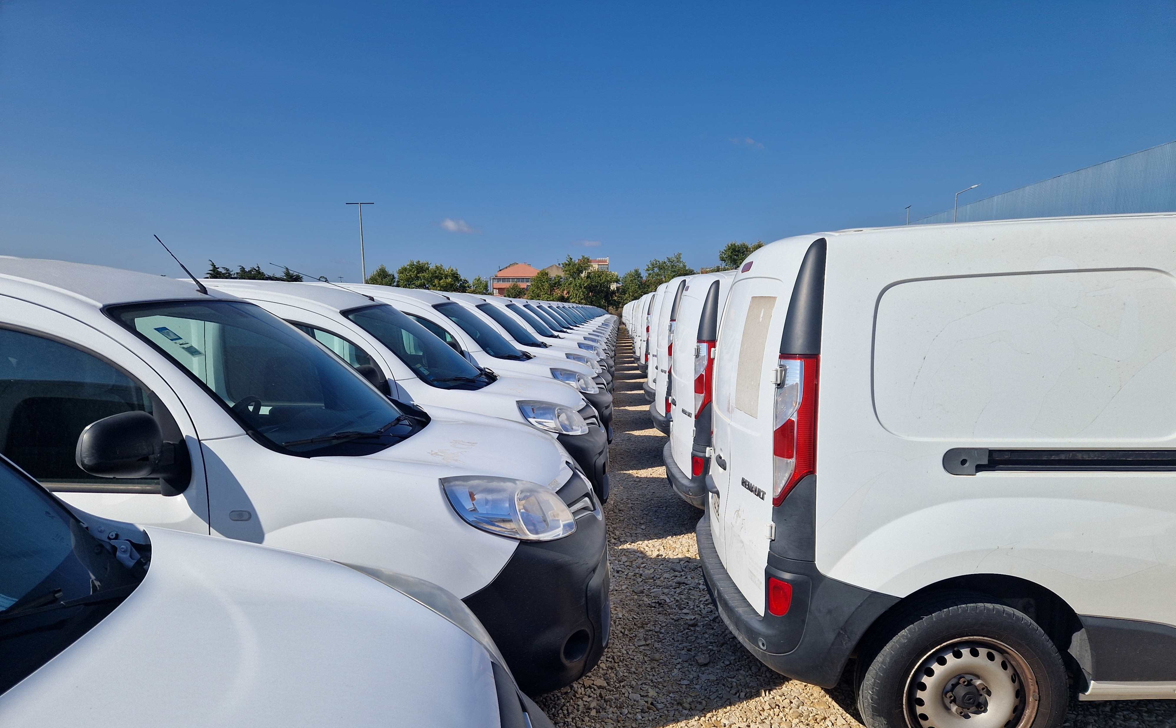 Amplo parque de estacionamento exterior com vários carros.