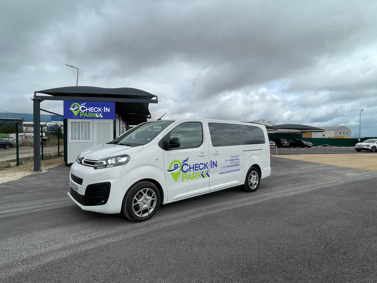 Shuttle branco moderno em frente a um terminal de aeroporto.