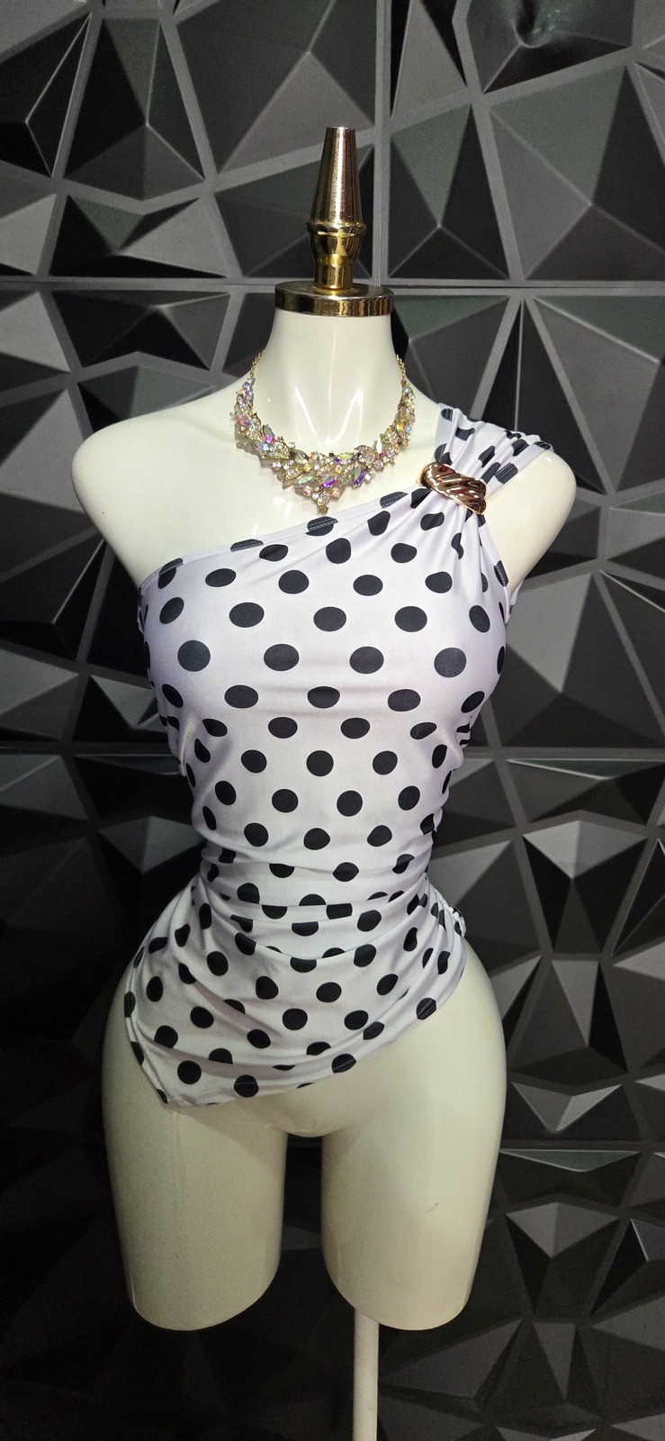 Blusa asimétrica de un hombro con hebilla de lunares