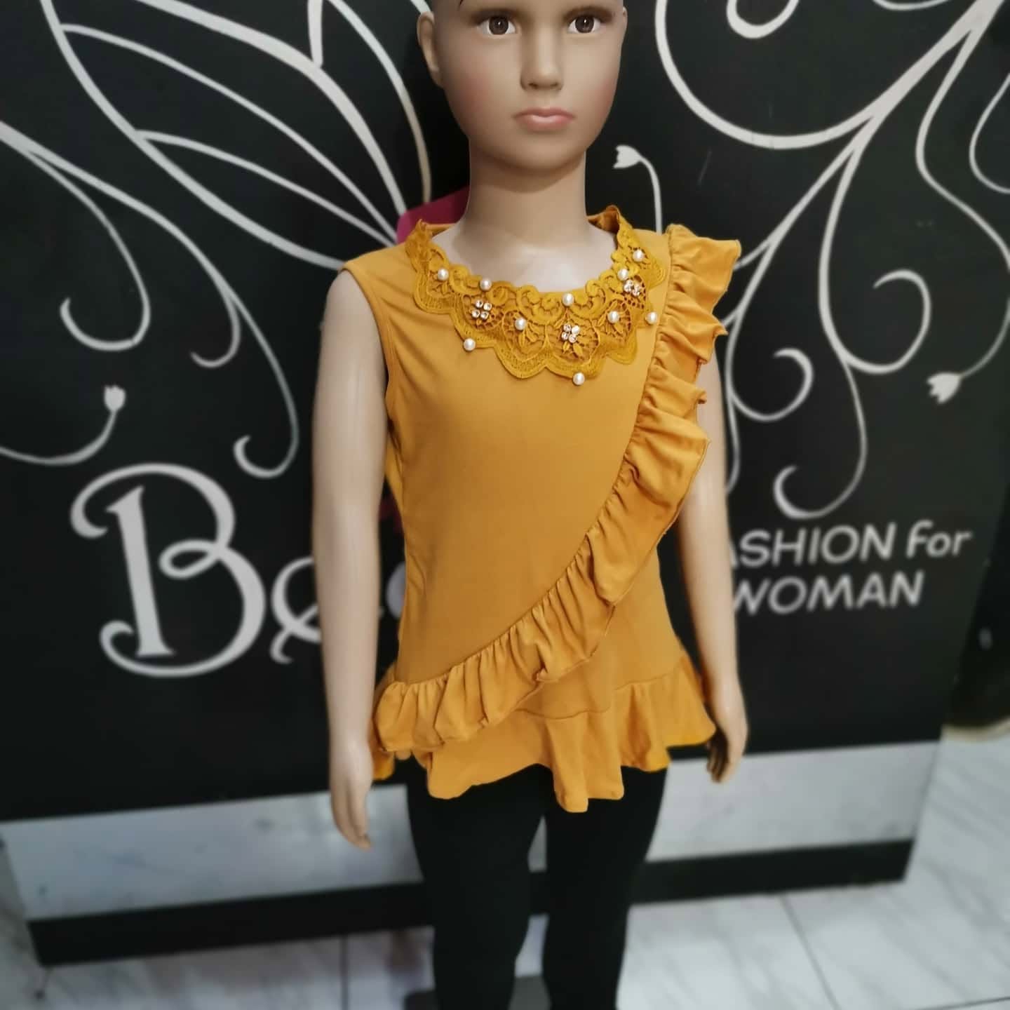 Blusa de niña sin mangas con cuello de encaje y olán diagonal