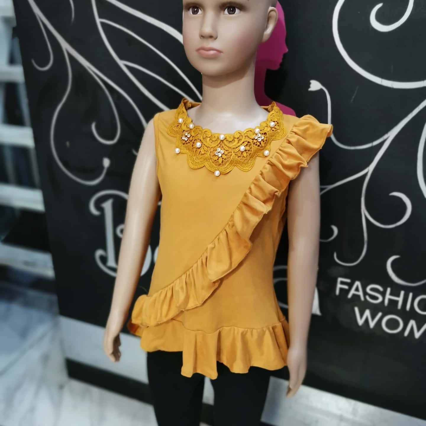 Blusa de niña sin mangas con cuello de encaje y olán diagonal