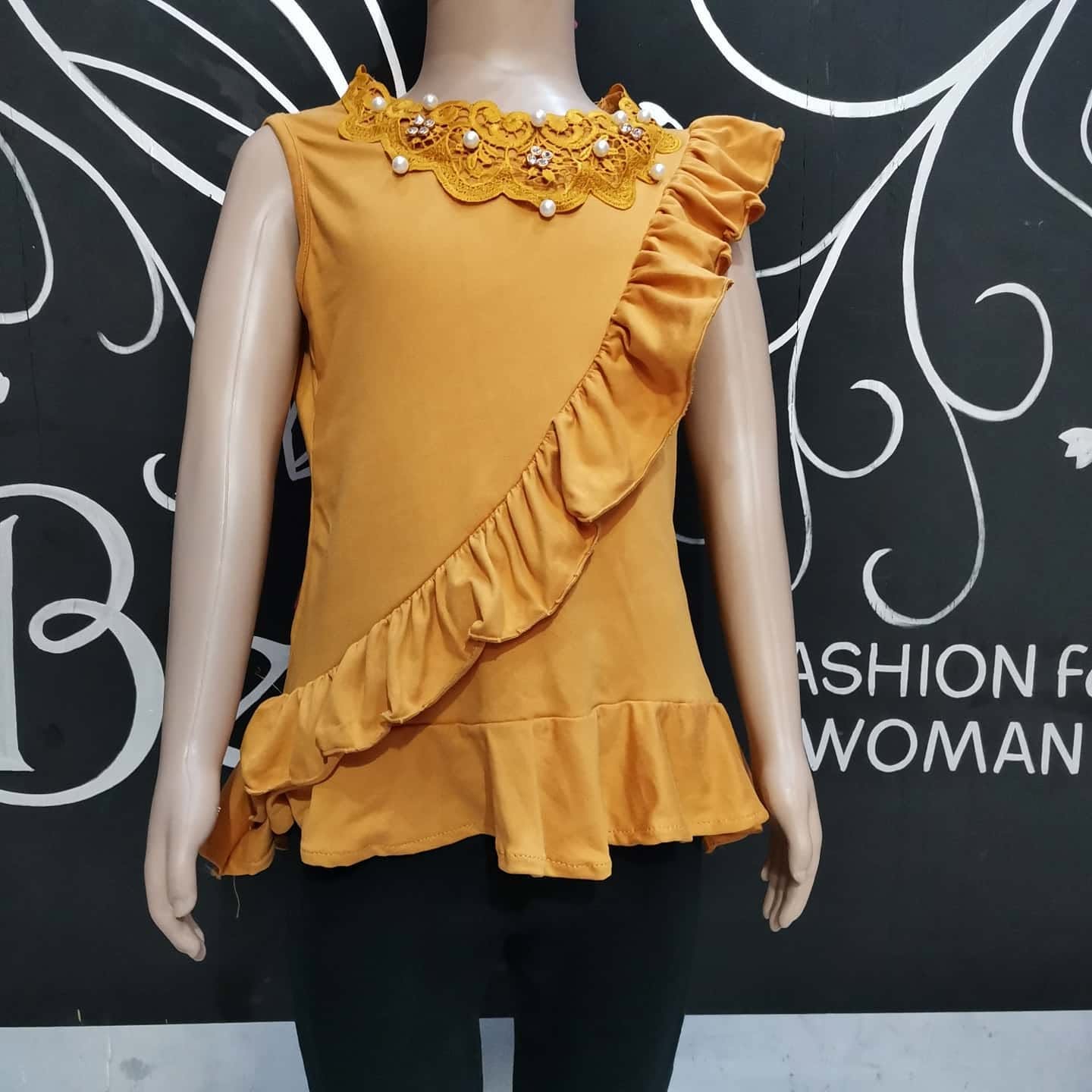 Blusa de niña sin mangas con cuello de encaje y olán diagonal