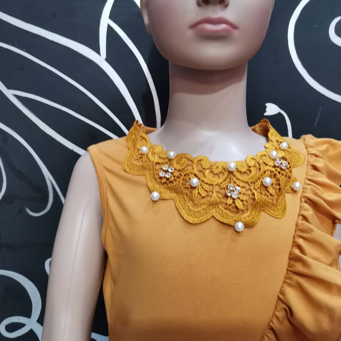 Blusa de niña sin mangas con cuello de encaje y olán diagonal