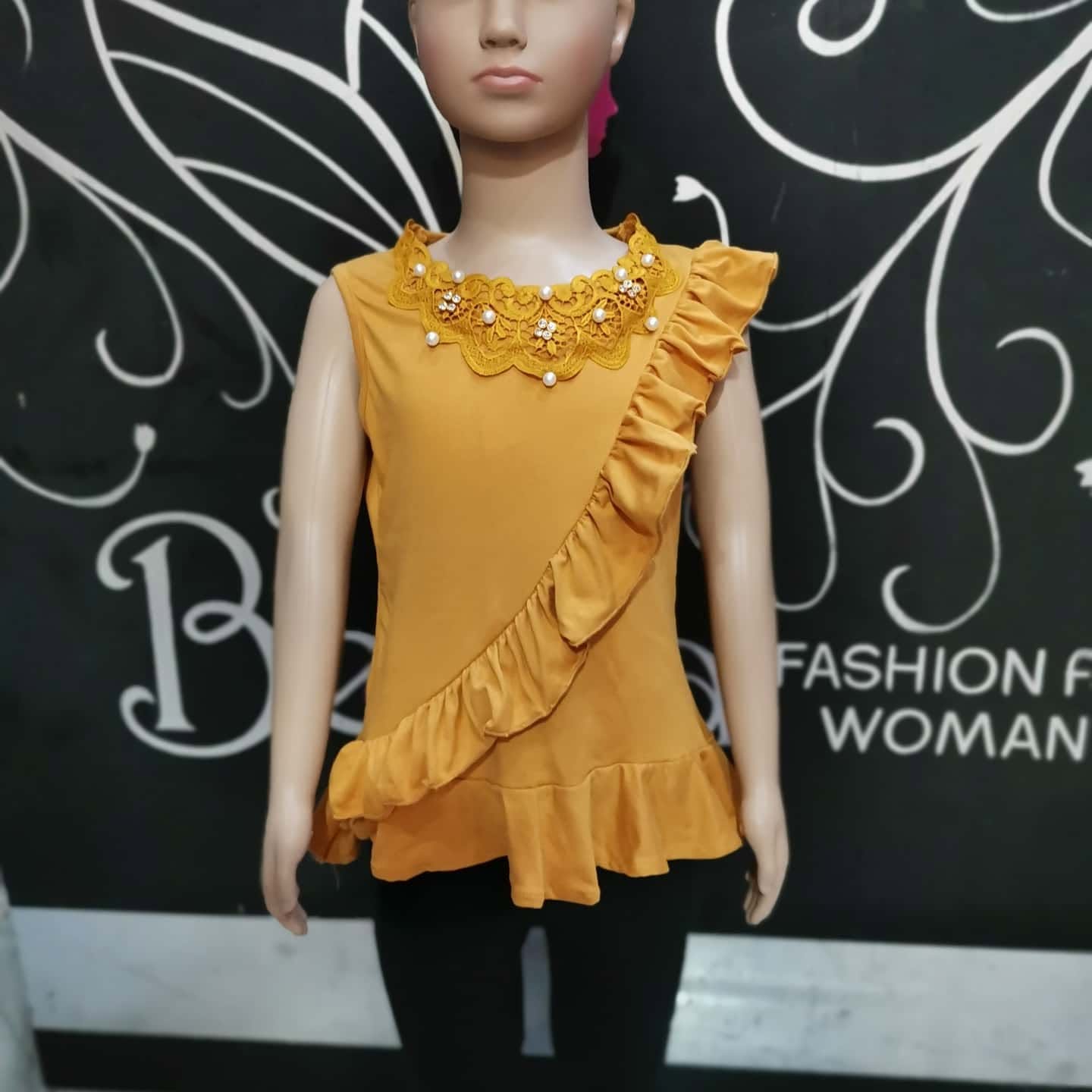 Blusa de niña sin mangas con cuello de encaje y olán diagonal