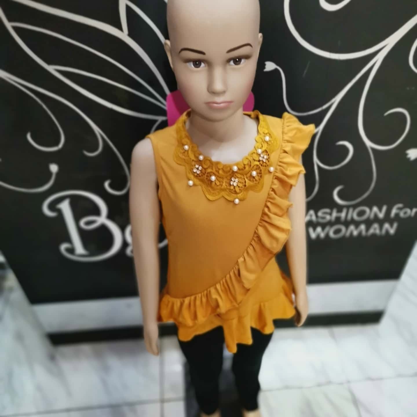 Blusa de niña sin mangas con cuello de encaje y olán diagonal