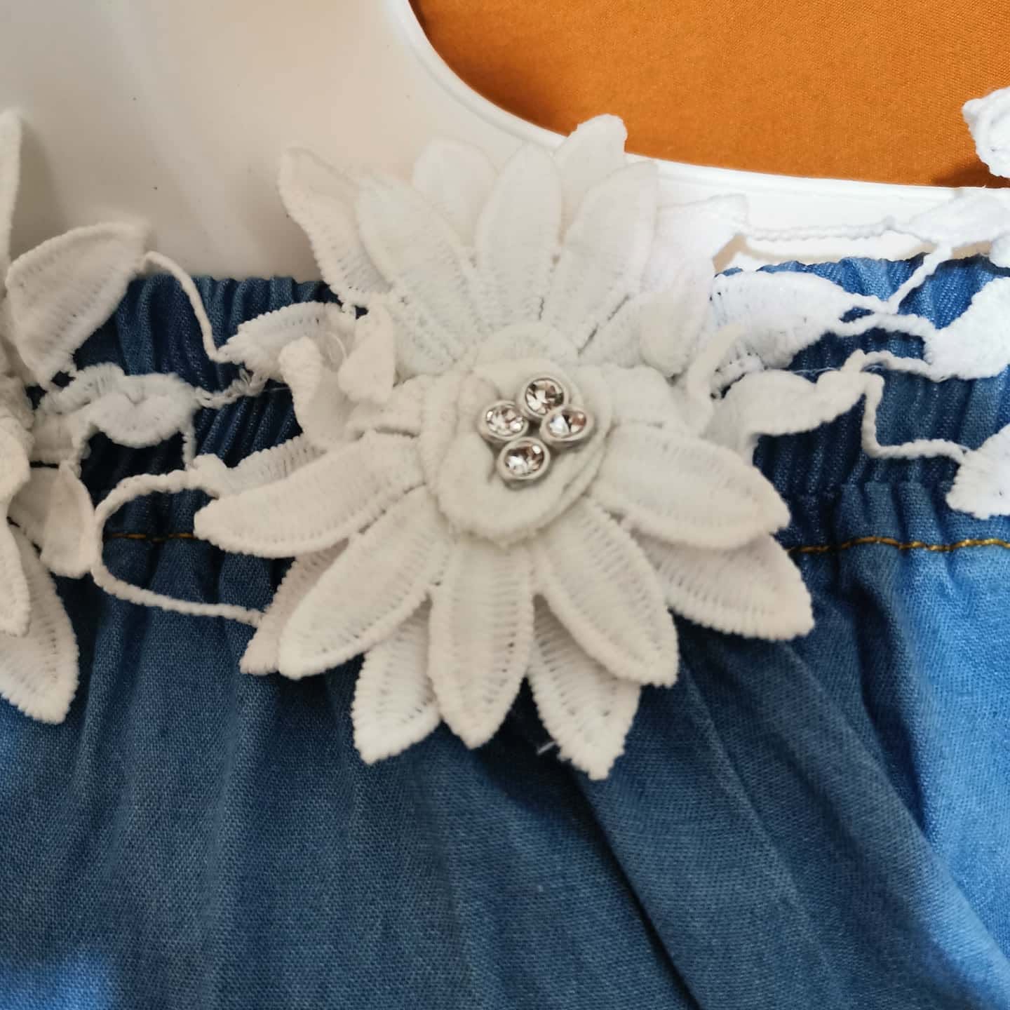 Blusa de mezclilla de niña con hombros descubiertos y flores de encaje