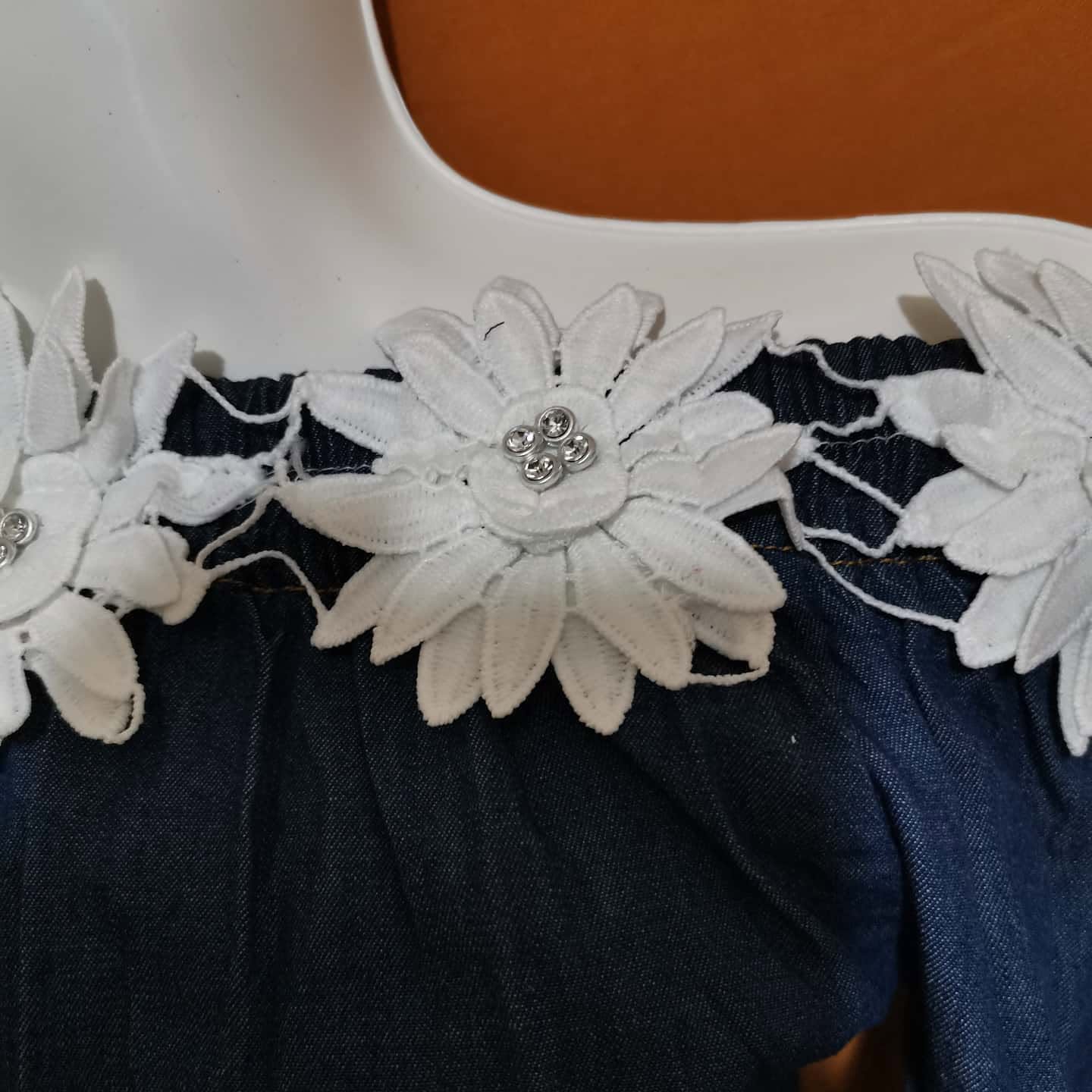 Blusa de mezclilla de niña con hombros descubiertos y flores de encaje