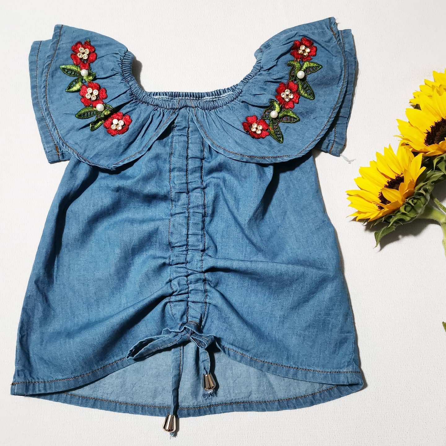 Blusa de mezclilla de niña con olán bordado de flores y jareta