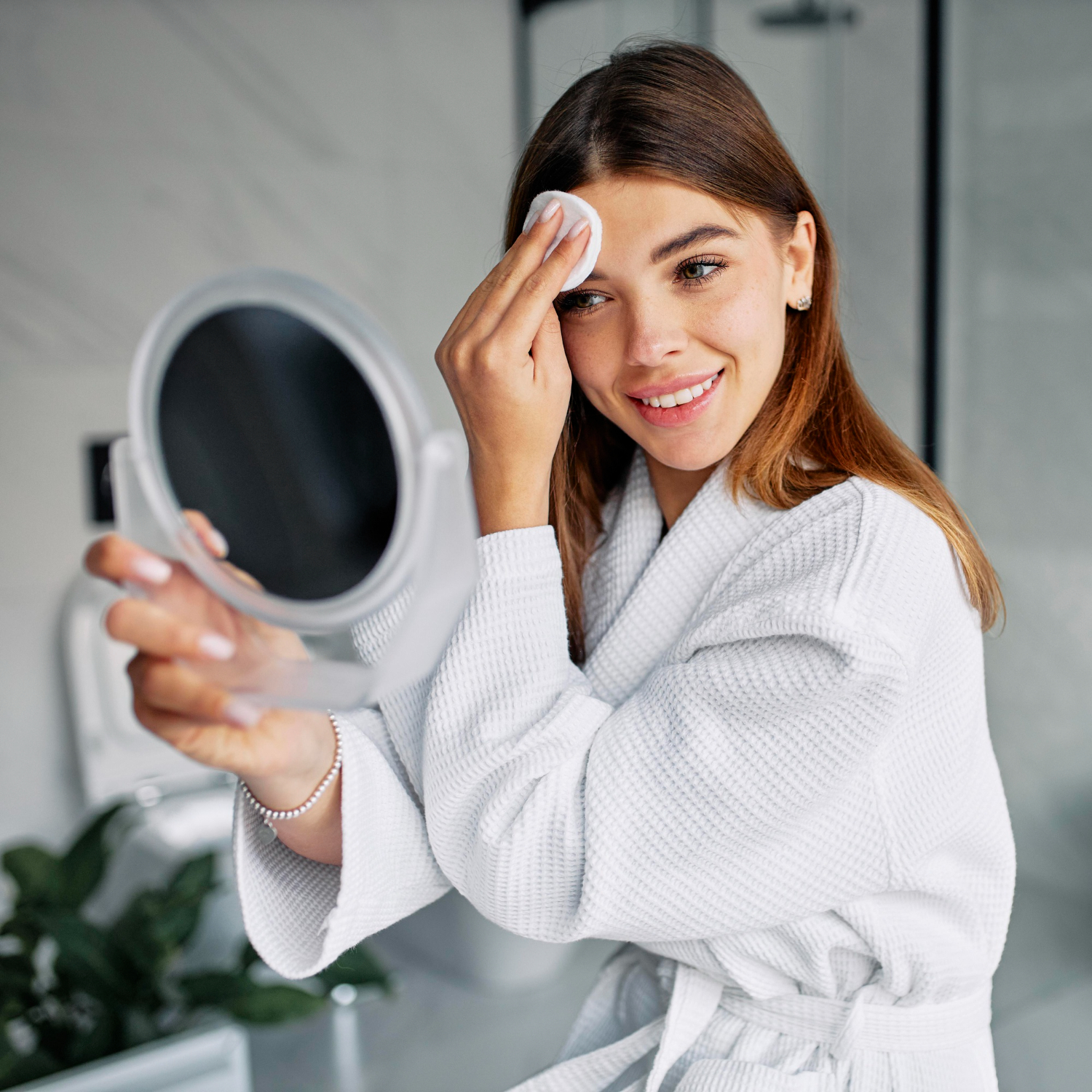 *****A woman washing her face with a mild cleanser in front of a mirror.