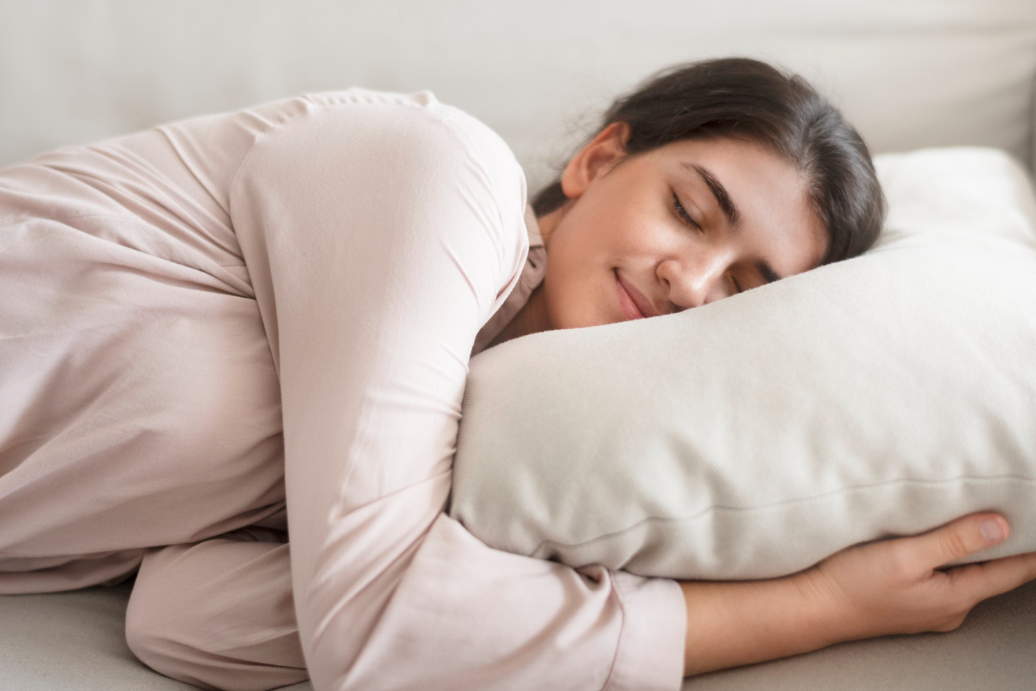 A woman sleeping peacefully on a pillow.