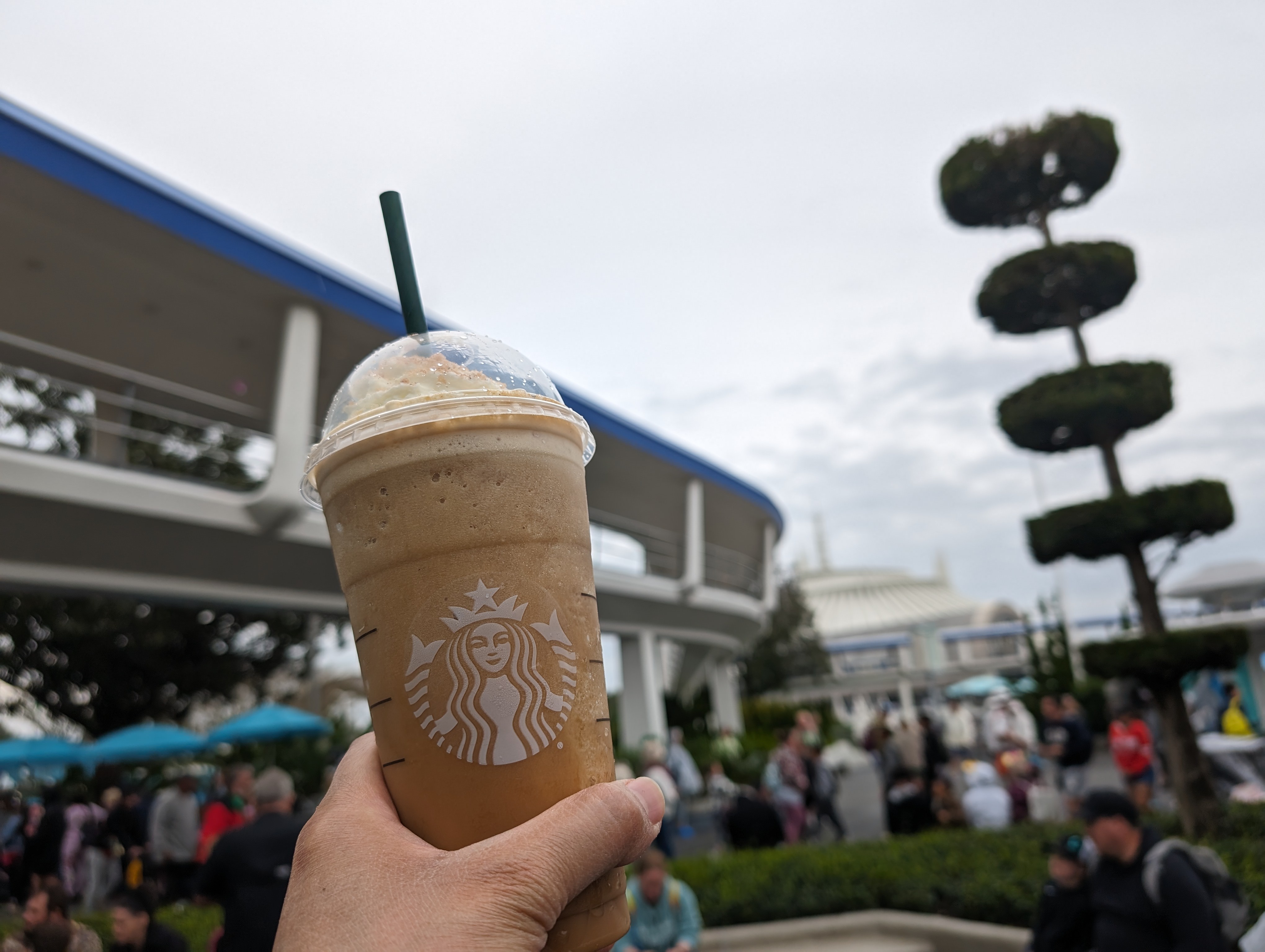 Drinking a chestnut praline almond milk frappuccino between rides in Tomorrowland