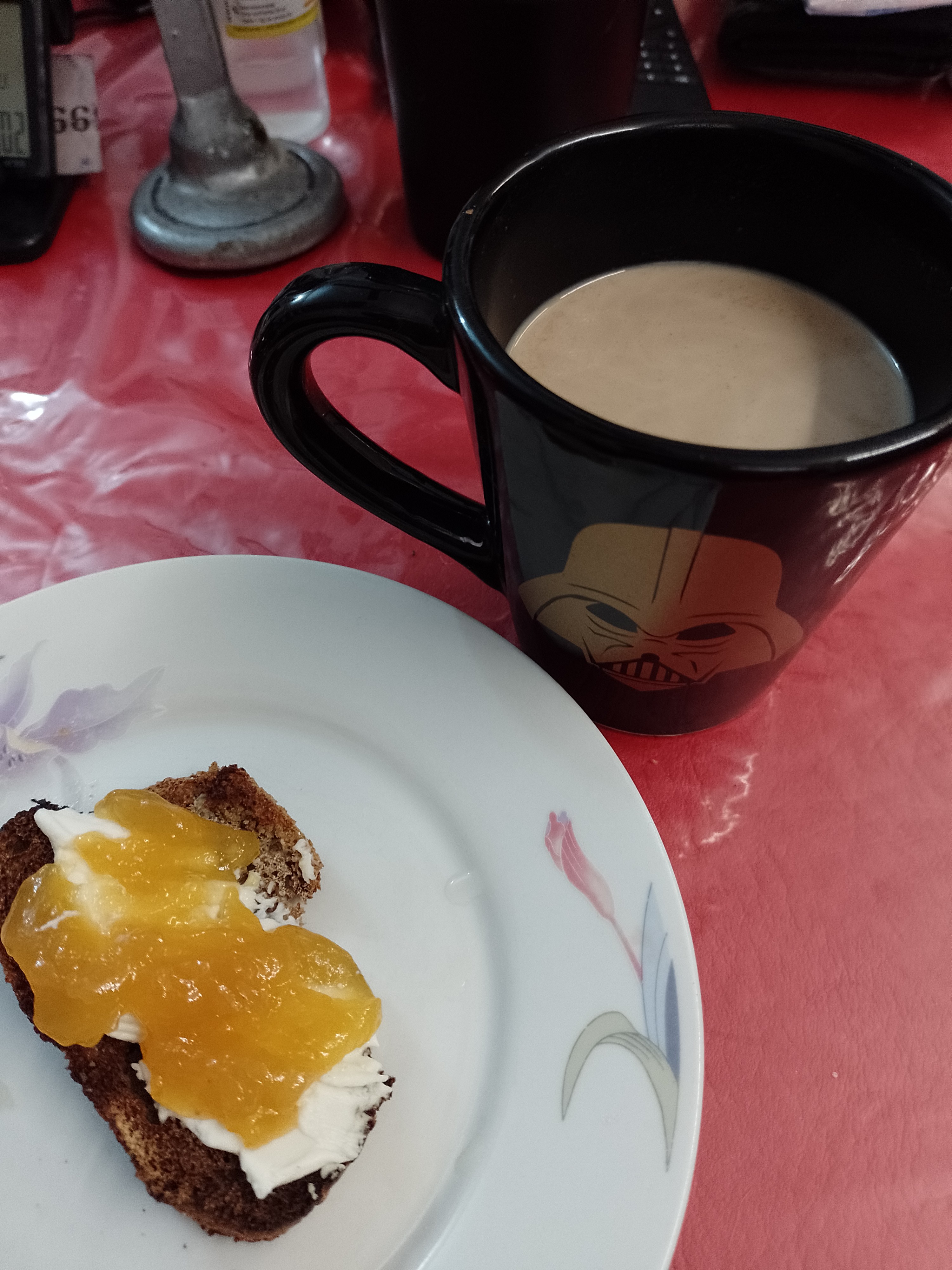 café Nestlé gold , con leche y cacao en polvo, acompañado con una tostada de pan casero de trigo sarraceno y harina común, con queso crema y mermelada de damasco